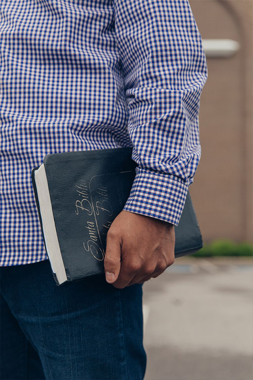 Cesar holding a bible