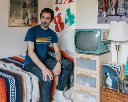 Shervin in his bedroom, featuring 1980s decor.